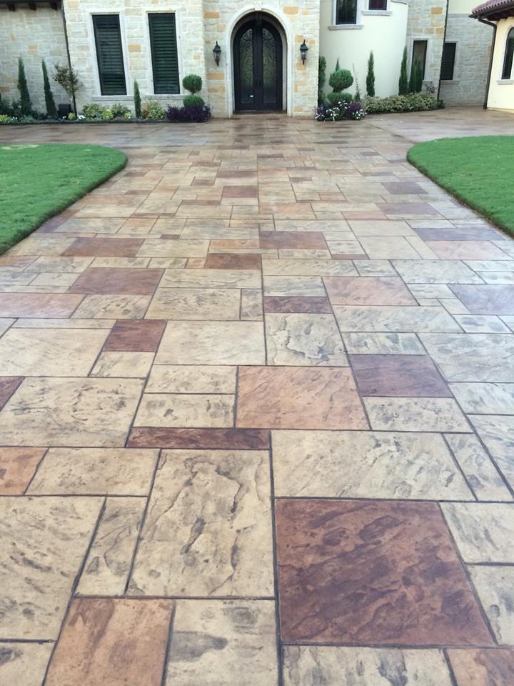 Stamped concrete driveway leading up to a stately home